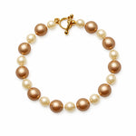 Pulsera de perlas café y crema sobre fondo blanco