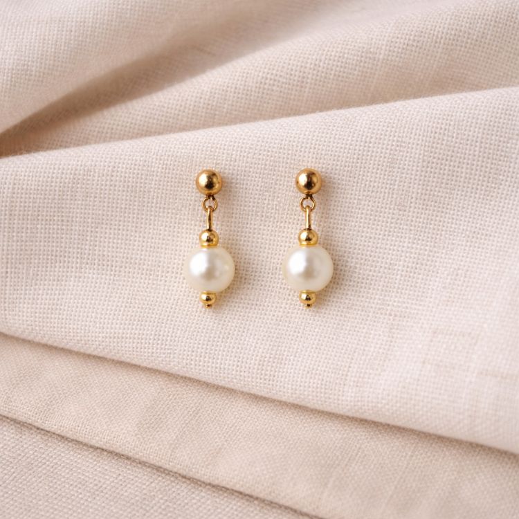 Aretes de perla blanca en flat lay elegante