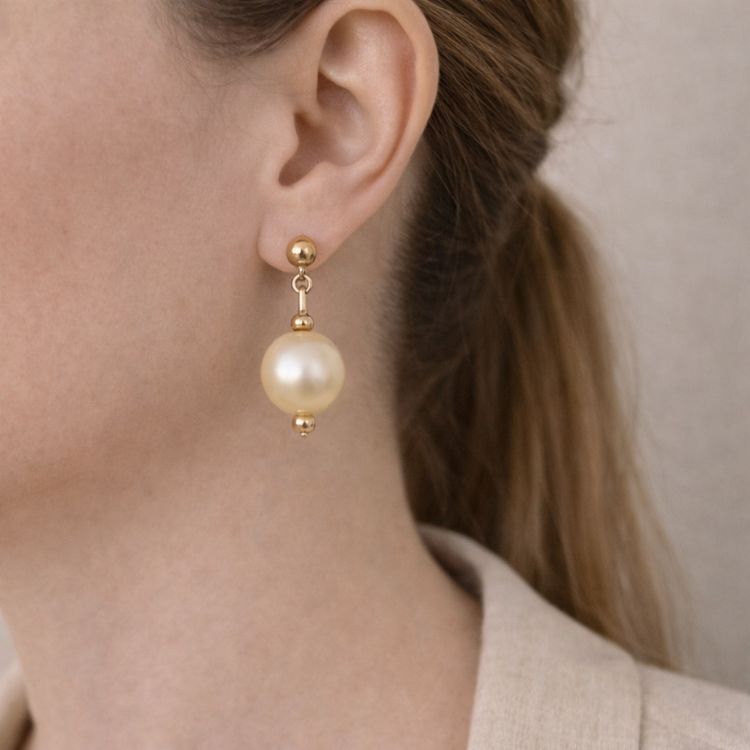 Perfil mostrando aretes de perla crema grandes