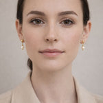 Mujer usando aretes de perla crema delicados