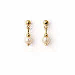 Aretes de perla crema 6 mm sobre fondo blanco