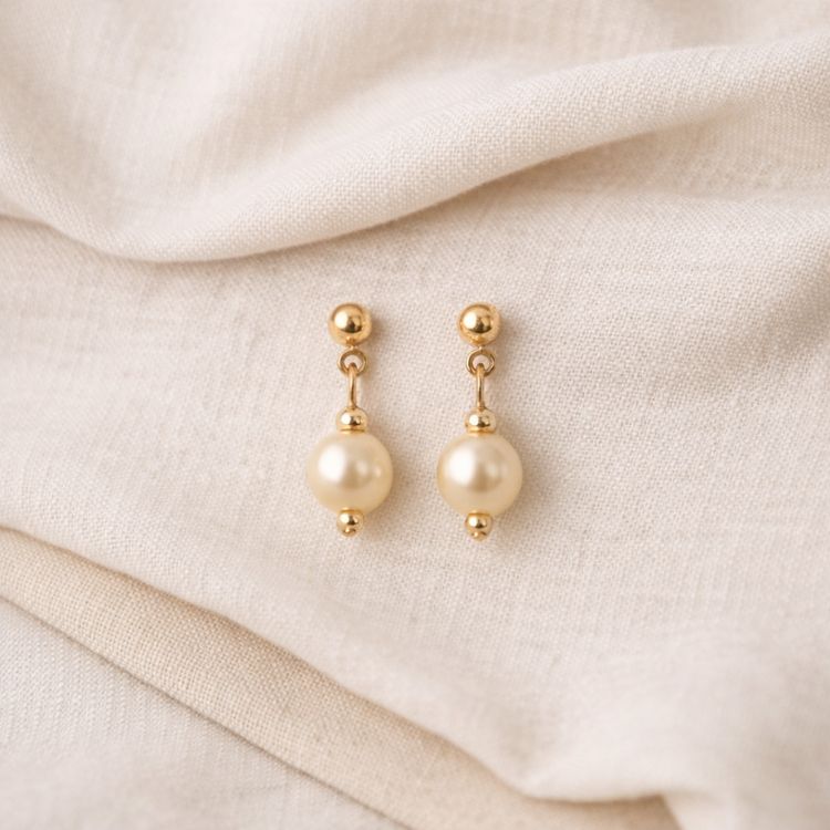 Aretes de perla crema en flat lay suave
