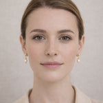 Mujer usando aretes de perla crema elegantes