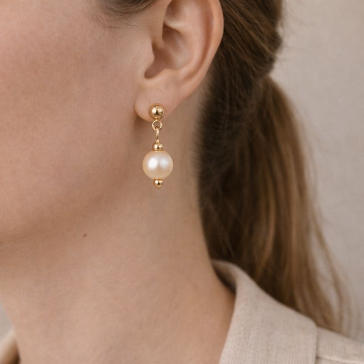 Perfil mostrando aretes de perla crema equilibrados