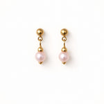 Aretes de perla rosa pastel 6 mm sobre fondo blanco