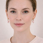 Mujer usando aretes de perla rosa pastel elegantes