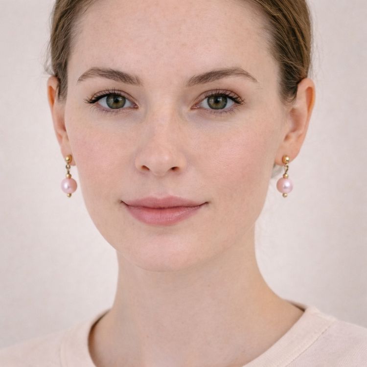 Mujer usando aretes de perla rosa pastel elegantes