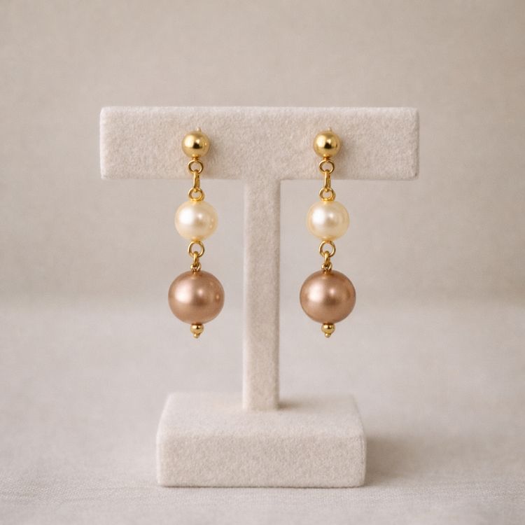 Aretes de perlas café y crema en exhibidor