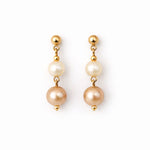 Aretes de perlas café y crema sobre fondo blanco