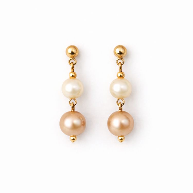 Aretes de perlas café y crema sobre fondo blanco