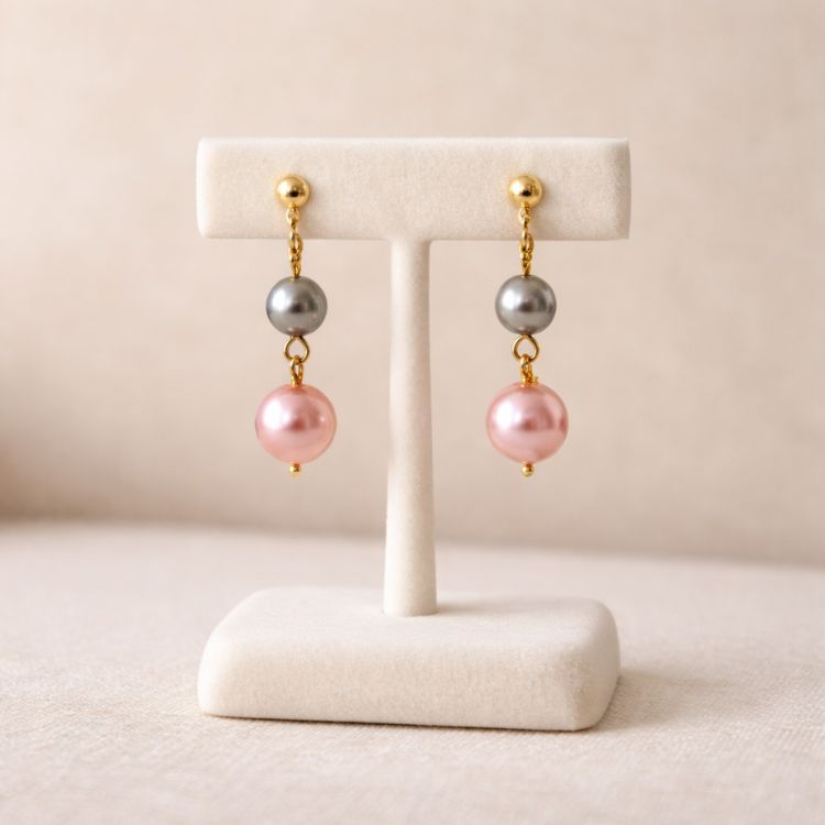 Aretes de perlas rosa y gris en exhibidor