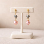 Aretes de perlas rosa y gris en exhibidor