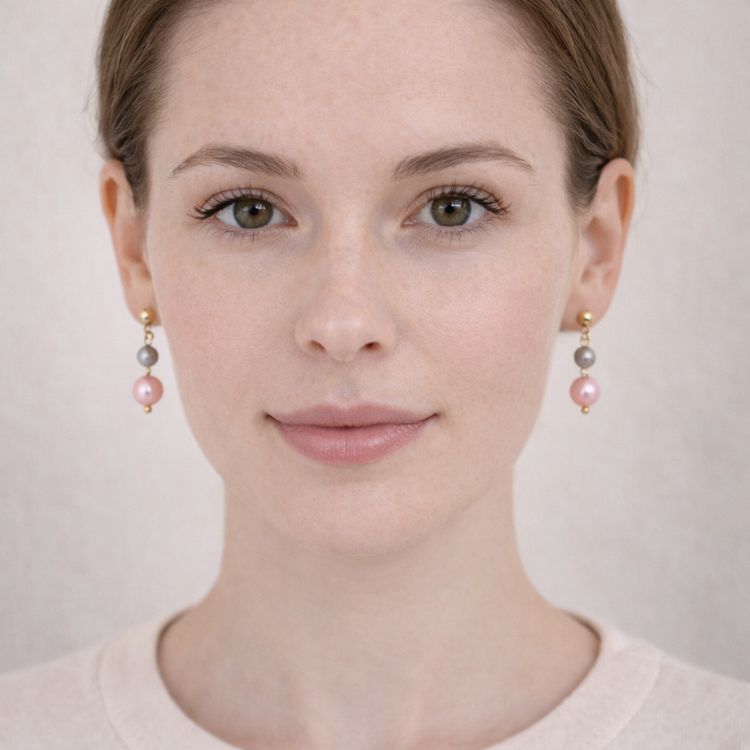 Mujer usando aretes de perlas bicolor elegantes