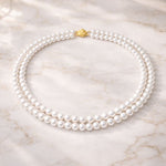 Collar doble de perla blanca sobre mármol