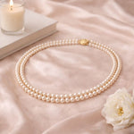 Collar doble de perla crema en flat lay minimalista