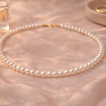 Collar de perla blanca pequeño en composición minimalista