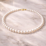 Collar de perla blanca sobre superficie de mármol