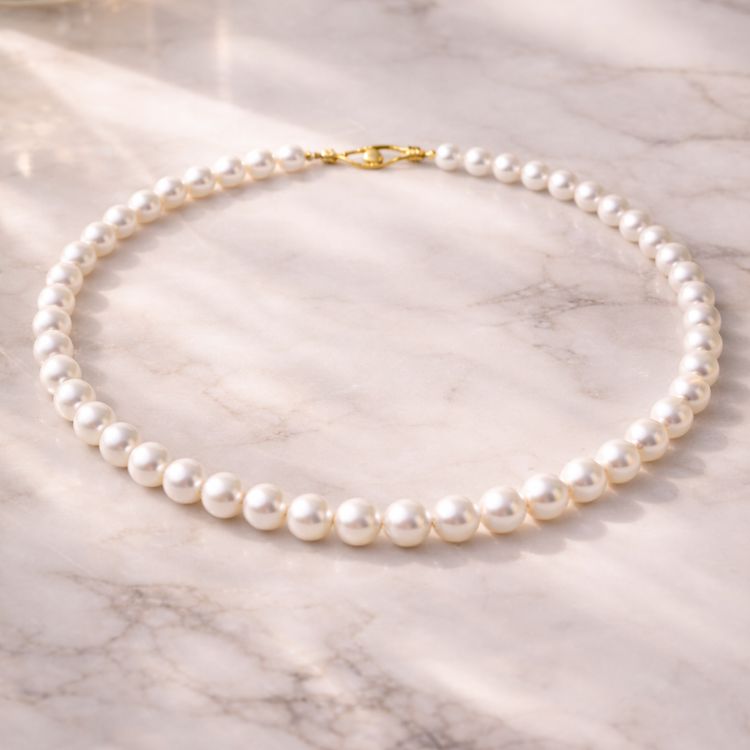 Collar de perla blanca sobre superficie de mármol