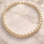 Collar de perla crema grande sobre mármo