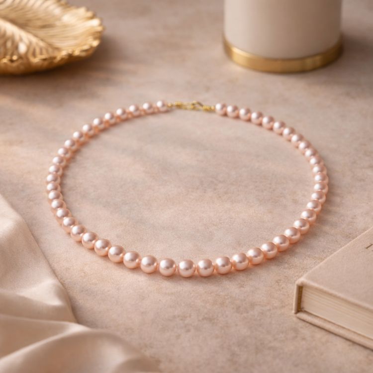 Collar de perla rosa pastel en flat lay femenino