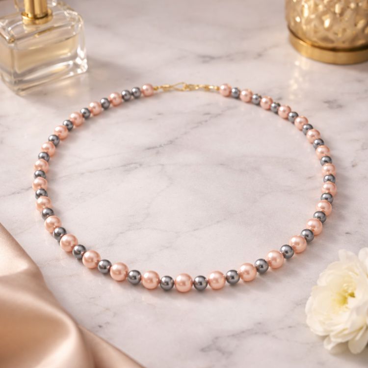 Collar de perlas rosa gris sobre superficie de mármol