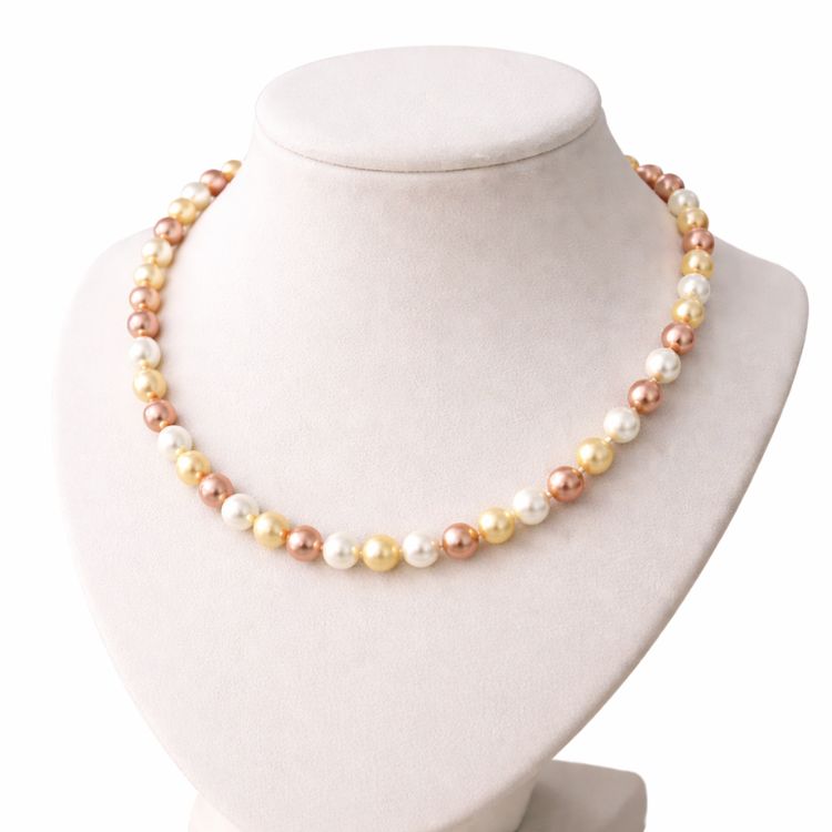 Collar de perlas tricolor en cuello exhibidor