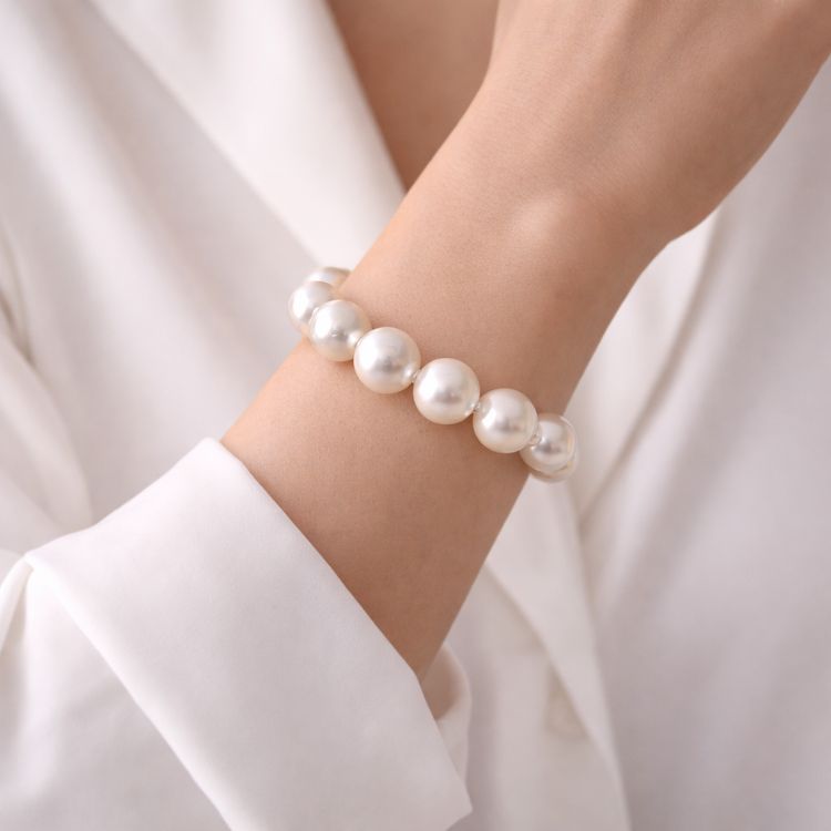 Mujer usando pulsera de perla blanca protagonista