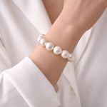 Mujer usando pulsera de perla blanca protagonista