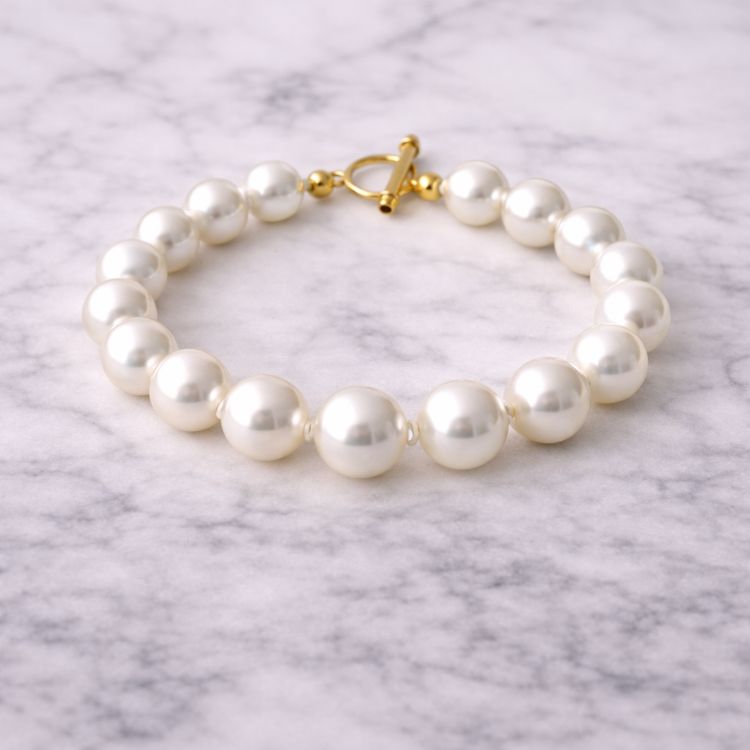 Pulsera de perla blanca grande sobre mármol