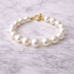 Pulsera de perla blanca grande sobre mármol