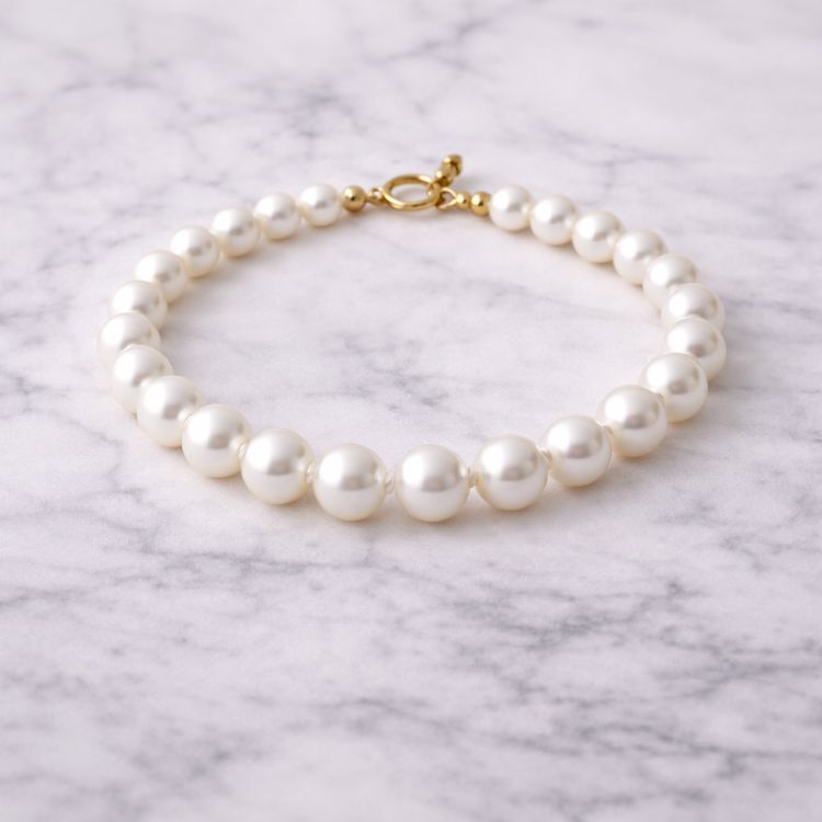 Pulsera de perla blanca sobre superficie de mármol
