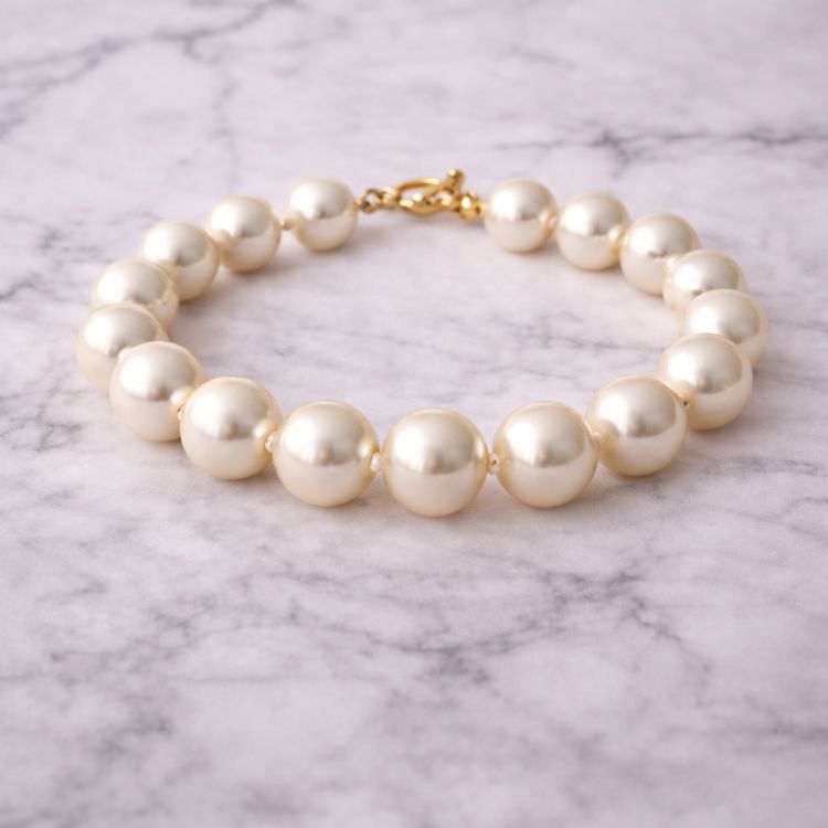 Pulsera de perla crema grande sobre mármol