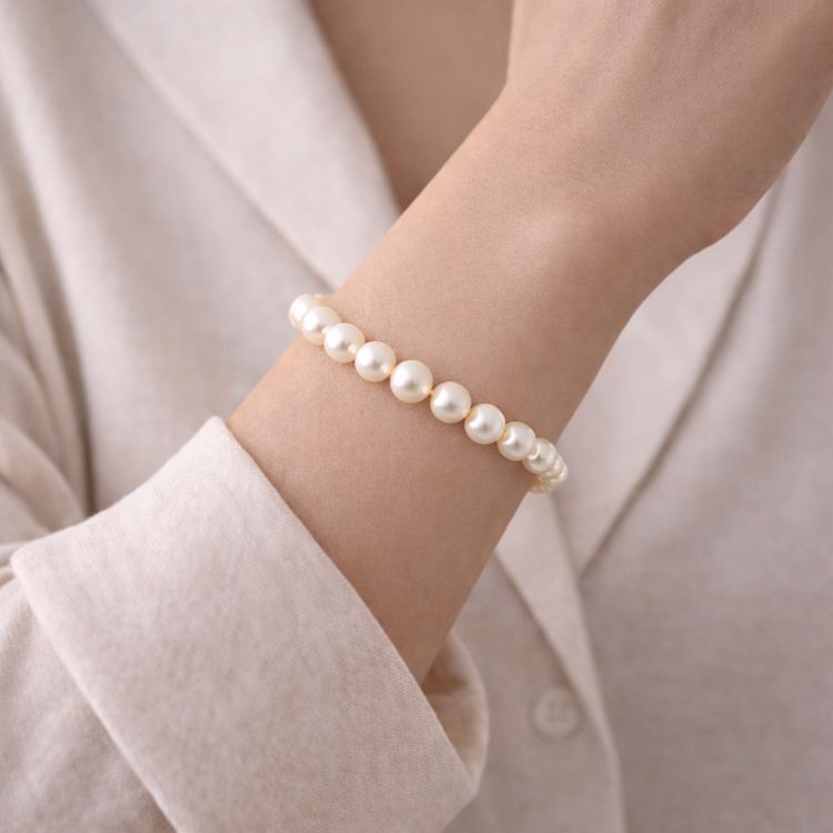 Mujer usando pulsera de perla crema delicada