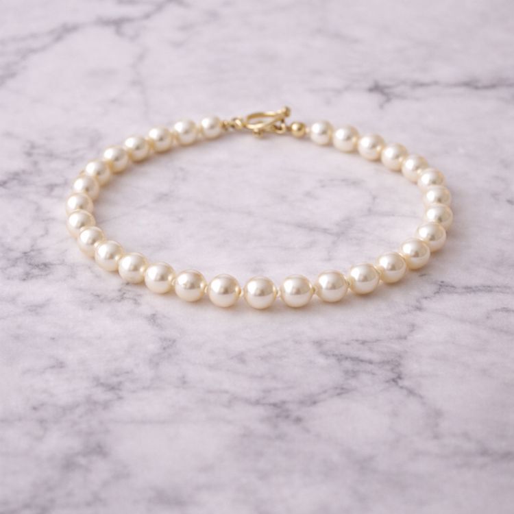 Pulsera de perla crema fina sobre mármol