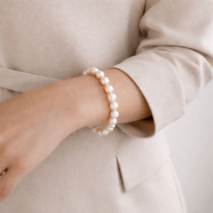 Mujer usando pulsera de perla crema elegante