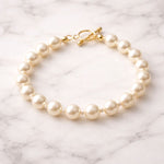 Pulsera de perla crema sobre superficie de mármol