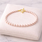 Pulsera de perla rosa pastel 6 mm en exhibidor