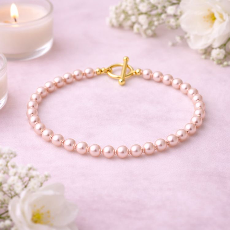 Pulsera de perla rosa pastel en composición estética