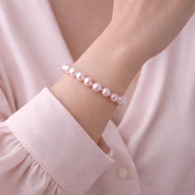 Mujer usando pulsera de perla rosa pastel delicada