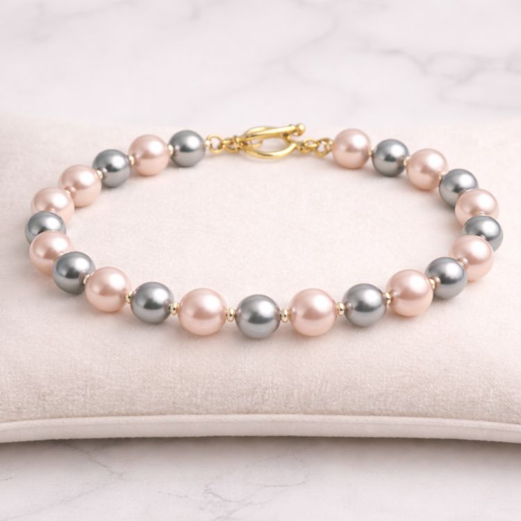 Pulsera de perlas rosa y gris en exhibidor