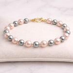 Pulsera de perlas rosa y gris en exhibidor