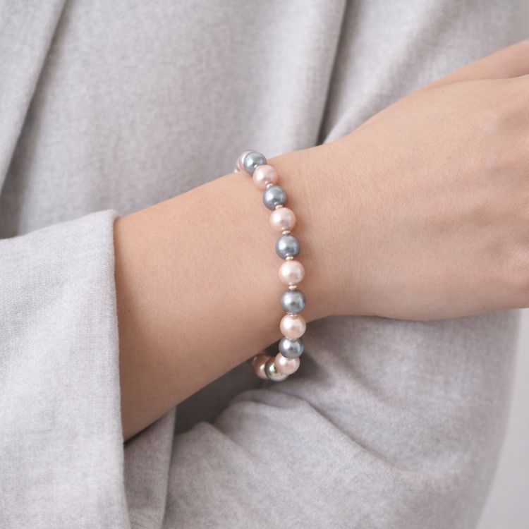 Mujer usando pulsera de perlas bicolor elegante