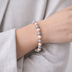 Mujer usando pulsera de perlas bicolor elegante