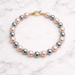 Pulsera de perlas rosa gris sobre mármol