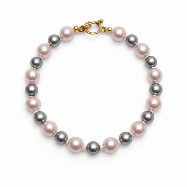 Pulsera de perlas rosa y gris sobre fondo blanco