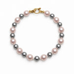 Pulsera de perlas rosa y gris sobre fondo blanco